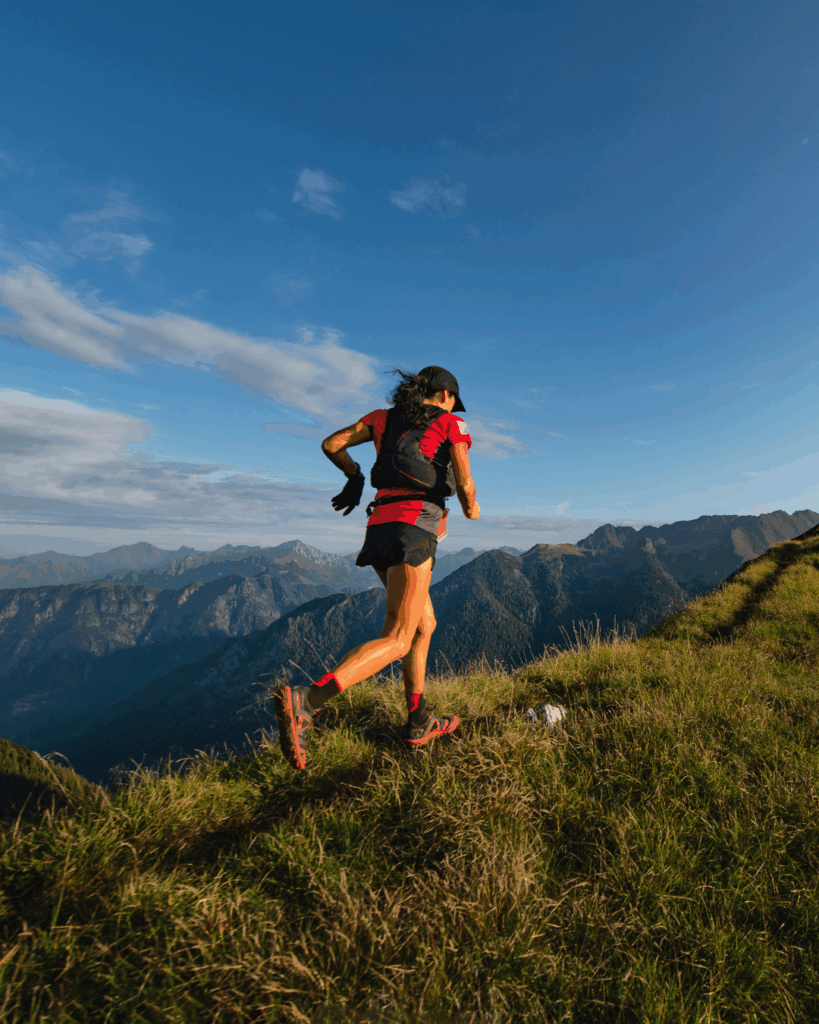 Une personne courant en trail sur un sentier de montagne.