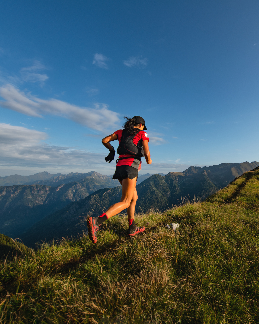 Une personne courant en trail sur un sentier de montagne.