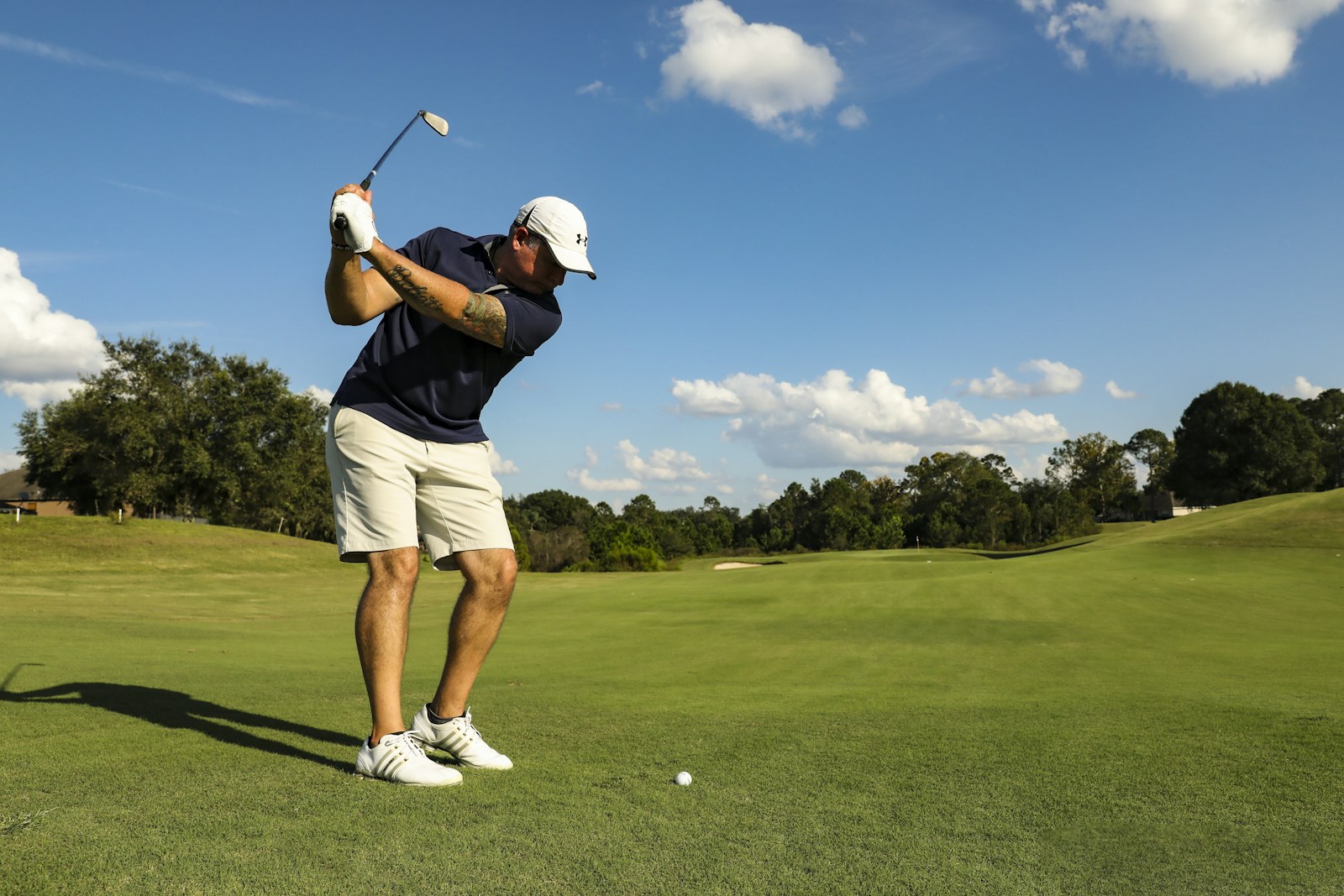 Golfeur en plein swing de driver sur un parcours : la préparation physique développe la puissance du swing